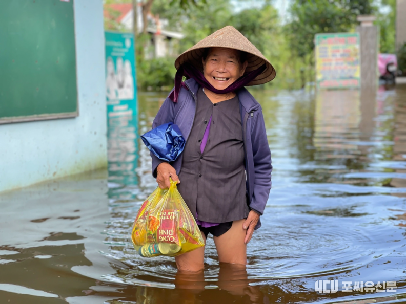 Nguyen Thi Xuan 여사(80세)는 라면과 식수를 사기 위해 거의 1km를 홍수 속을 걸어갔다. 사진출처: thanhnien.vn
